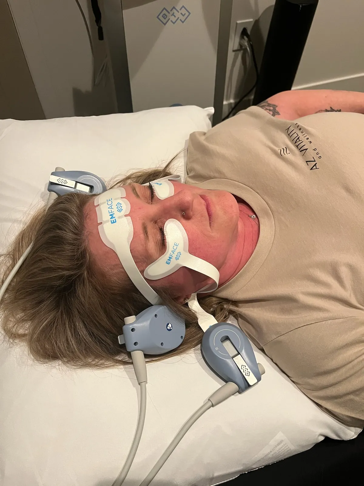 Melynda Fenn, FNP-C, founder of AZ Vitality and Wellness, relaxing with EMFACE pads on her forehead and cheeks during her own session at the Peoria clinic